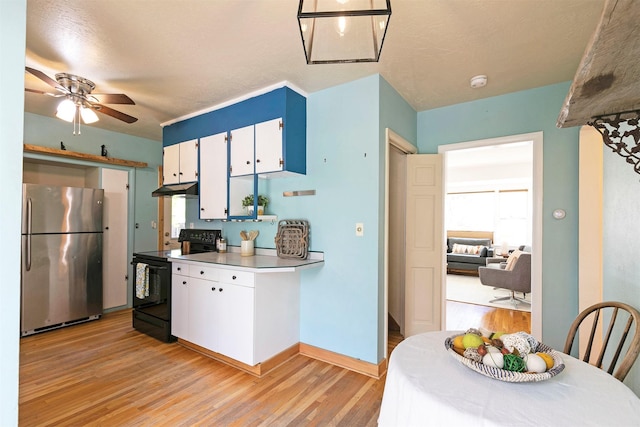 kitchen featuring black electric range oven, freestanding refrigerator, under cabinet range hood, light wood-style flooring, and white cabinetry