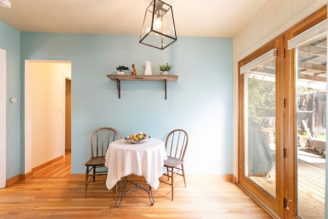 dining space with baseboards and wood finished floors