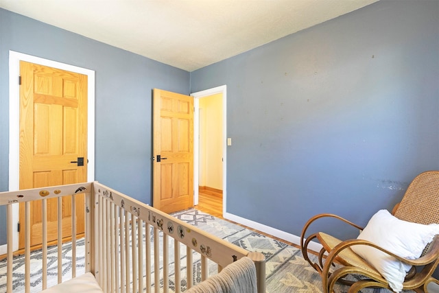 sitting room with baseboards and wood finished floors