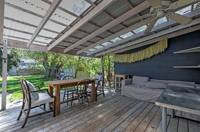 wooden deck with a yard, outdoor dining area, ceiling fan, and fence