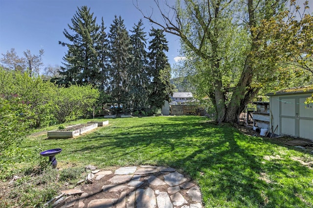 view of yard featuring a storage shed, a vegetable garden, an outbuilding, and a fenced backyard