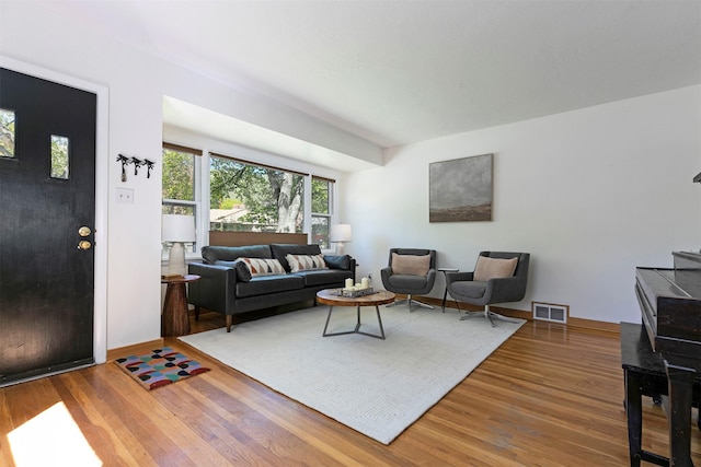 living area featuring visible vents and wood finished floors