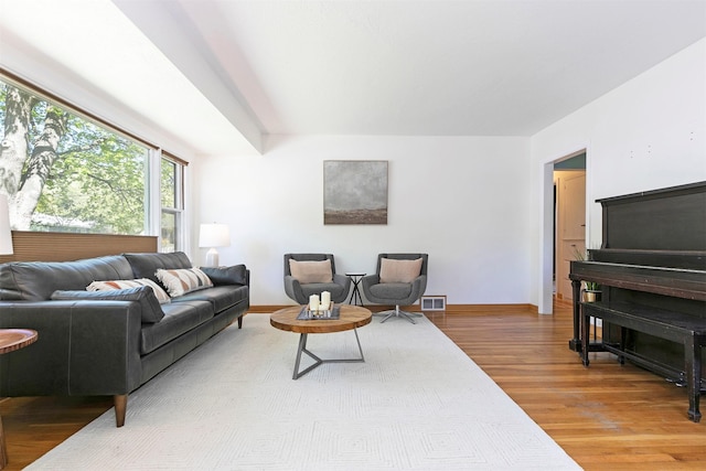 living area with baseboards, visible vents, and wood finished floors