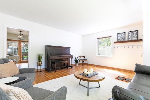 living area with baseboards and wood finished floors
