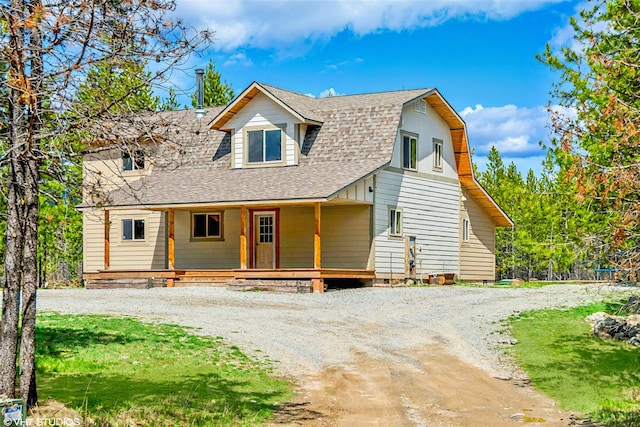 515 Gopher Ln, Marion, MT 59925 - view of front facade with a shingled roof, a porch, driveway, and a front yard