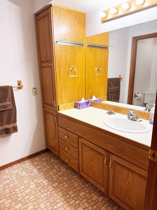 105 Garden Dr Unit D, Kalispell, MT 59901 - bathroom featuring vanity, toilet, and baseboards
