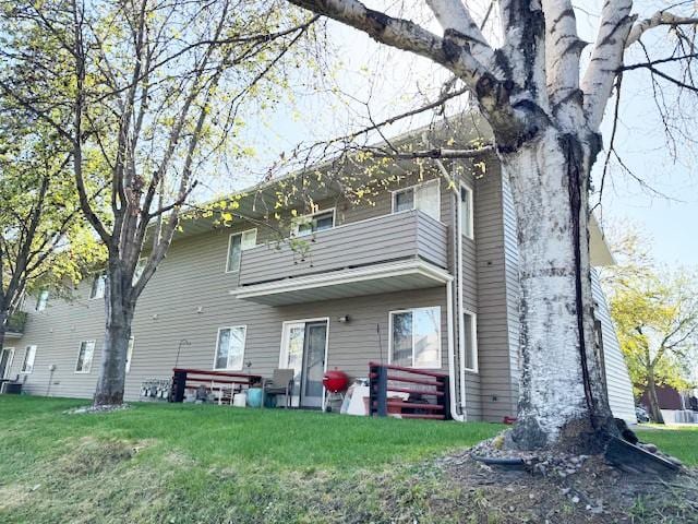 105 Garden Dr Unit D, Kalispell, MT 59901 - back of house with a lawn and a balcony