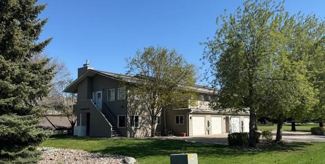 105 Garden Dr Unit D, Kalispell, MT 59901 - back of house with a yard, concrete driveway, and a garage