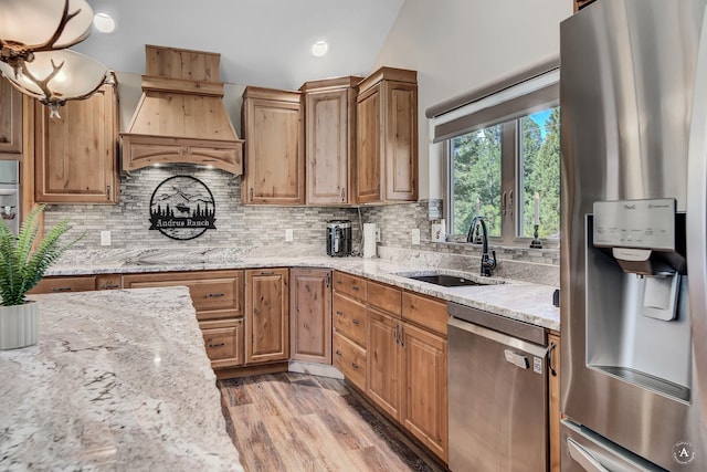 617 Mcclellan Creek Rd, Clancy, MT 59634 - kitchen featuring appliances with stainless steel finishes, custom range hood, a sink, light stone countertops, and tasteful backsplash