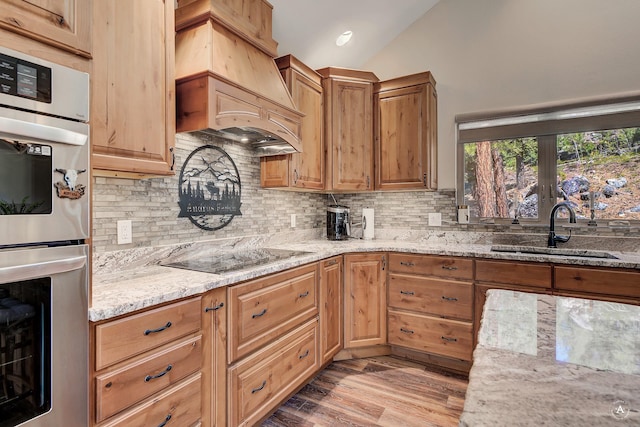 617 Mcclellan Creek Rd, Clancy, MT 59634 - kitchen with a sink, stainless steel double oven, premium range hood, light stone counters, and black electric stovetop