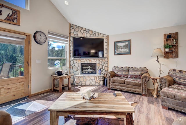 617 Mcclellan Creek Rd, Clancy, MT 59634 - living area with lofted ceiling, wood finished floors, and a stone fireplace