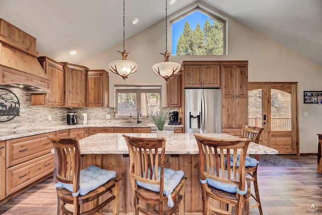617 Mcclellan Creek Rd, Clancy, MT 59634 - kitchen with stainless steel fridge with ice dispenser, high vaulted ceiling, black electric stovetop, a center island, and tasteful backsplash