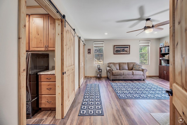 617 Mcclellan Creek Rd, Clancy, MT 59634 - living area featuring a barn door, a ceiling fan, wood finished floors, and recessed lighting
