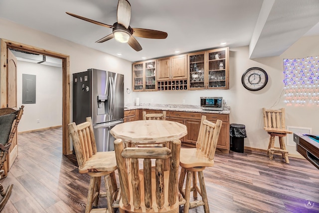 617 Mcclellan Creek Rd, Clancy, MT 59634 - dining space with wood finished floors, bar area, ceiling fan, baseboards, and electric panel