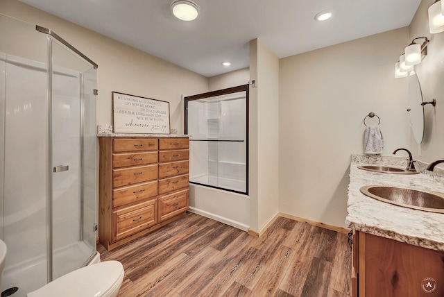 617 Mcclellan Creek Rd, Clancy, MT 59634 - bathroom featuring wood finished floors, double vanity, toilet, baseboards, and recessed lighting