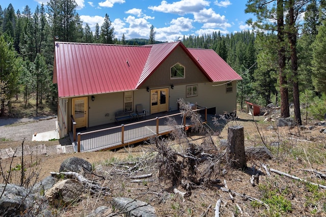 617 Mcclellan Creek Rd, Clancy, MT 59634 - rear view of house featuring metal roof, a wooden deck, and a view of trees