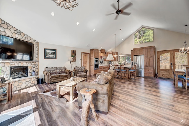 617 Mcclellan Creek Rd, Clancy, MT 59634 - living room featuring a chandelier, high vaulted ceiling, a fireplace, ceiling fan, and wood finished floors