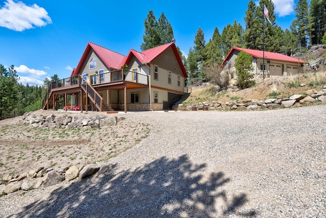 617 Mcclellan Creek Rd, Clancy, MT 59634 - view of side of property with stairs, a wooden deck, and a metal roof