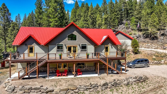 617 Mcclellan Creek Rd, Clancy, MT 59634 - back of property featuring stairway, a wooden deck, stone siding, and metal roof