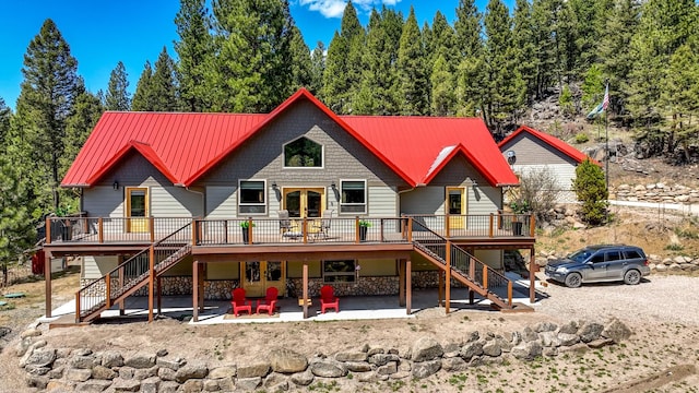 617 Mcclellan Creek Rd, Clancy, MT 59634 - back of house featuring stairway, a deck, stone siding, and metal roof