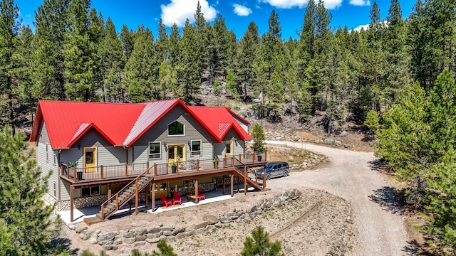 617 Mcclellan Creek Rd, Clancy, MT 59634 - back of house with stairway, a wooden deck, dirt driveway, and metal roof