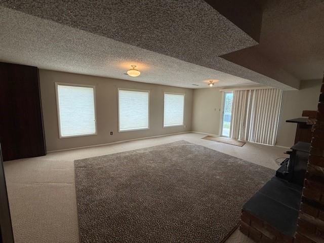 120 29th Ave NW, Great Falls, MT 59404 - unfurnished living room featuring carpet floors, a wood stove, and a textured ceiling