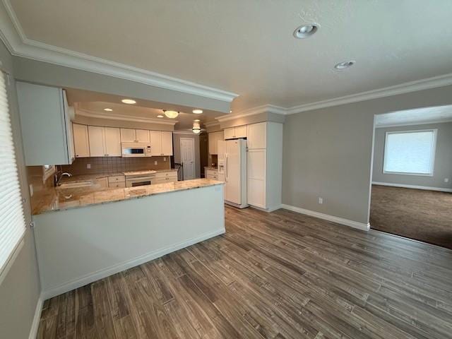 120 29th Ave NW, Great Falls, MT 59404 - kitchen featuring white appliances, crown molding, open floor plan, dark wood-type flooring, and a peninsula