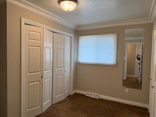 120 29th Ave NW, Great Falls, MT 59404 - unfurnished bedroom with a closet, dark colored carpet, ornamental molding, baseboards, and a textured ceiling