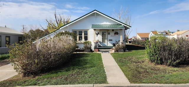 bungalow with a front lawn and metal roof