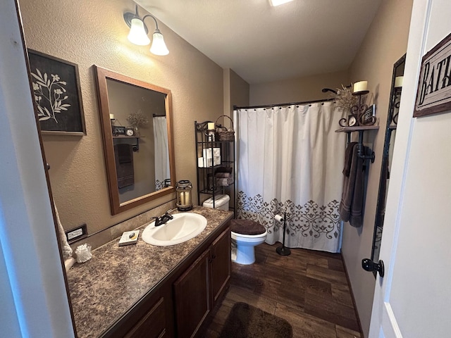 55 Mills Rd, Whitehall, MT 59759 - full bath featuring wood finished floors, toilet, vanity, a textured wall, and curtained shower