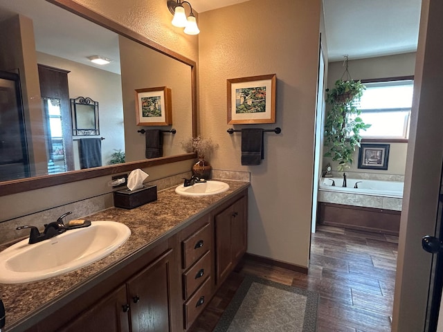 55 Mills Rd, Whitehall, MT 59759 - full bathroom featuring double vanity, a garden tub, wood finished floors, and baseboards