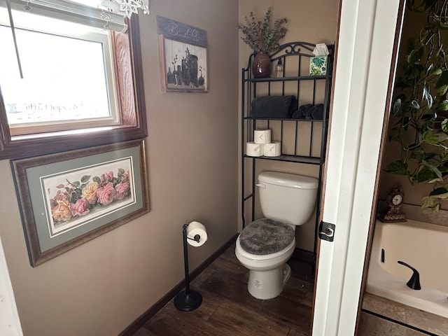 55 Mills Rd, Whitehall, MT 59759 - bathroom featuring toilet, baseboards, and wood finished floors