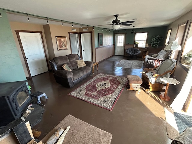 55 Mills Rd, Whitehall, MT 59759 - living room featuring a wood stove, concrete floors, and a ceiling fan
