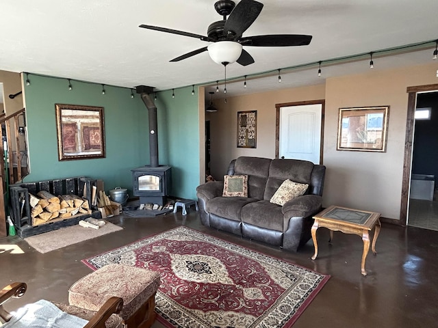 55 Mills Rd, Whitehall, MT 59759 - living area with concrete floors, ceiling fan, a wood stove, and stairs