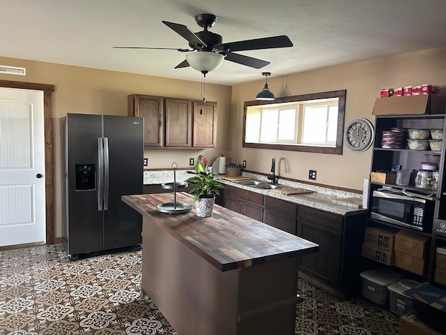 55 Mills Rd, Whitehall, MT 59759 - kitchen featuring stainless steel refrigerator with ice dispenser, wood counters, black microwave, ceiling fan, and a center island
