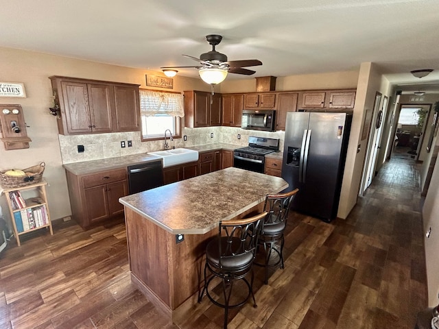 55 Mills Rd, Whitehall, MT 59759 - kitchen featuring appliances with stainless steel finishes, a sink, dark wood-type flooring, and a center island