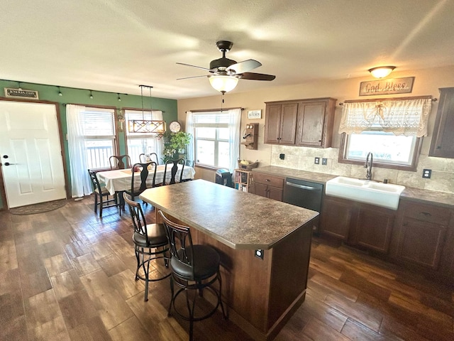55 Mills Rd, Whitehall, MT 59759 - kitchen featuring a sink, dark wood finished floors, ceiling fan, a center island, and tasteful backsplash