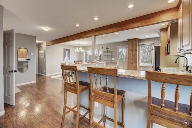 710 Joslyn St, Helena, MT 59601 - kitchen with stainless steel appliances, recessed lighting, a breakfast bar area, beamed ceiling, and light stone counters