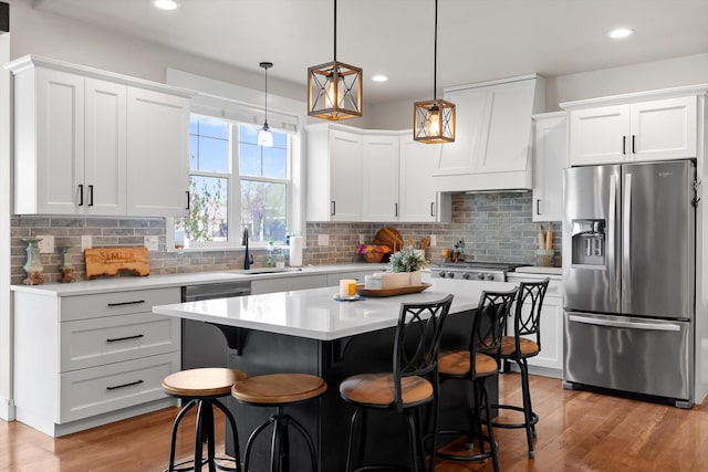 200 Ali Loop, Kalispell, MT 59901 - kitchen featuring stainless steel appliances, light countertops, light wood-type flooring, a breakfast bar, and recessed lighting