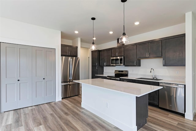 NHNLOT2 England Blvd, Missoula, MT 59808 - kitchen featuring appliances with stainless steel finishes, a sink, dark brown cabinets, a kitchen island, and light countertops