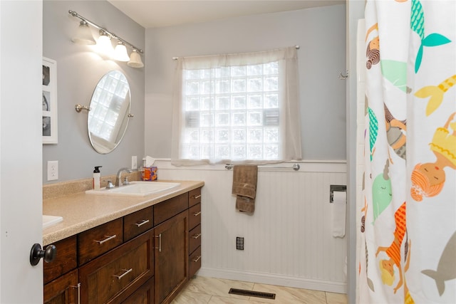 full bath with a wainscoted wall, vanity, and a shower with curtain