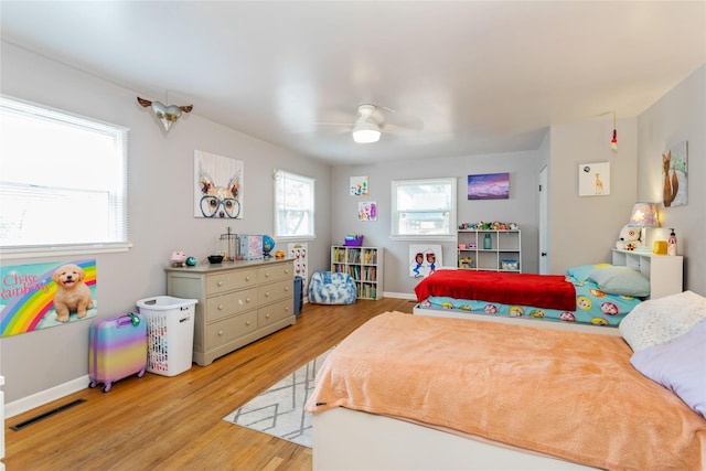 bedroom featuring wood finished floors, baseboards, and a ceiling fan