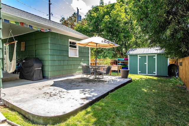 view of yard with a shed, an outbuilding, and a patio area