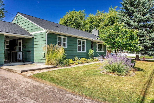 1004 Park Ave, Whitefish, MT 59937 - view of front of house with a chimney, a front yard, and a shingled roof