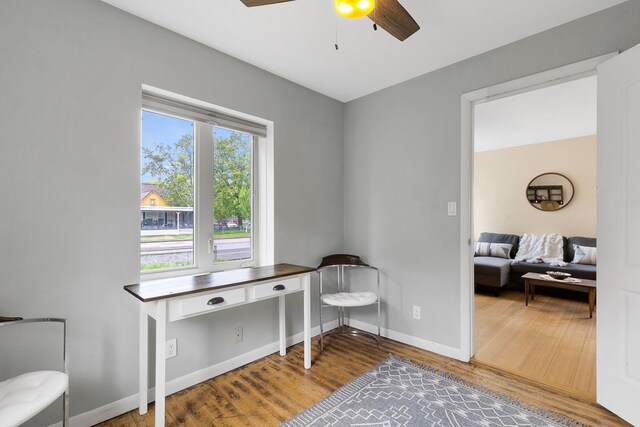 office featuring a ceiling fan, wood finished floors, and baseboards