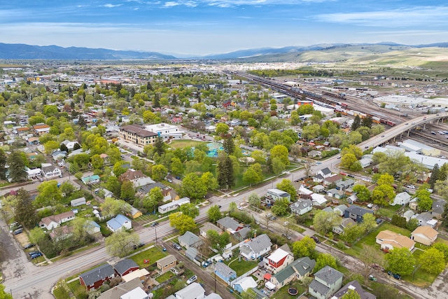 aerial view of property and surrounding area featuring a mountain backdrop and nearby suburban area