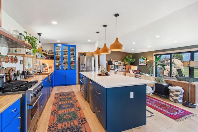33766 W Shore Dr, Polson, MT 59860 - kitchen featuring stainless steel appliances, blue cabinets, light wood finished floors, and recessed lighting