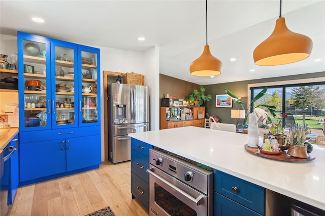 33766 W Shore Dr, Polson, MT 59860 - kitchen featuring stainless steel appliances, light wood finished floors, blue cabinetry, light countertops, and recessed lighting