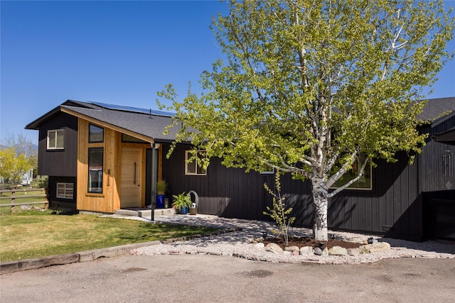 33766 W Shore Dr, Polson, MT 59860 - view of front facade with roof mounted solar panels and a shingled roof