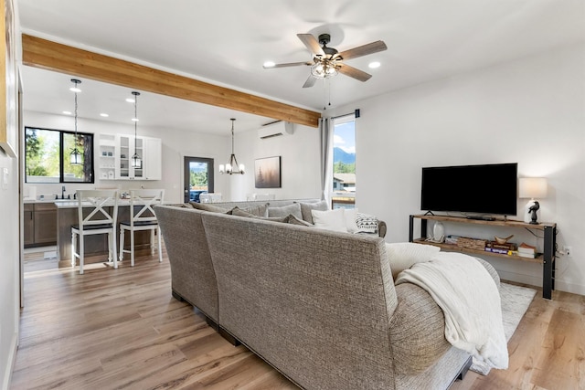 212 Water Way, Darby, MT 59829 - living room with a wall mounted air conditioner, a chandelier, a ceiling fan, light wood finished floors, and beamed ceiling